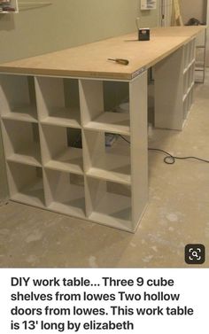 a table that has some shelves on it in the middle of a room with no furniture