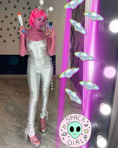 a woman with pink hair is holding a toothbrush in front of a mirror and some lights