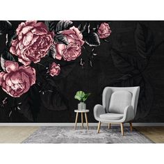 a living room with black and pink flowers on the wall next to a gray chair