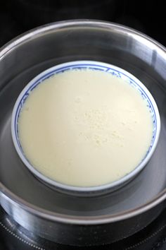 a bowl filled with liquid sitting on top of a stove