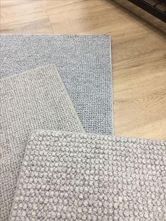 two gray rugs sitting on top of a wooden floor next to a computer keyboard