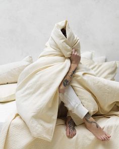 a person wrapped in a blanket on top of a bed