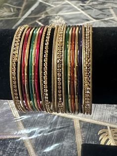 Add a touch of glamour to your special occasion with this beautiful multicoloured metal and thread work bangle set from My Jewel Box. The exquisite piece features natural stones and excellent cut grade that will surely catch everyone's attention. Perfect for engagement, wedding, anniversary, birthday, and Valentine's Day celebrations, this Indian/Pakistani bridalwear partywear jewellery is a great addition to your collection. The set is made of high-quality alloy material that guarantees durabil Multicolor Jeweled Bangle, Multicolor Bangle For Festive Occasions, Festive Multicolor Bangle Jewelry, Traditional Multicolor Metal Bangle, Elegant Multicolor Bangle For Celebration, Multicolor Bangle Jewelry With Stone Work, Adjustable Multicolor Bracelets For Diwali, Festive Multicolor Metal Bracelets, Multicolor Stone Work Bangle Jewelry