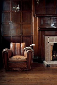 a living room with a chair, fireplace and chandelier