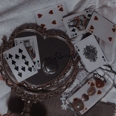 playing cards are laying on the bed next to an antique mirror and keychain