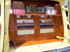 the back end of a yellow van with many items on it's shelves and drawers