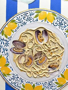 a plate of pasta with clams and sauce on a blue and white striped tablecloth