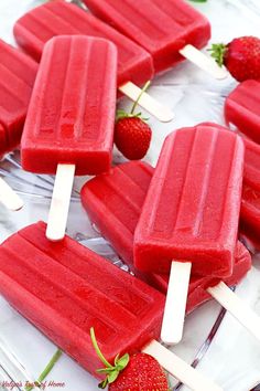 several popsicles with strawberries on them sitting on a plate