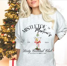 Celebrate the holidays in style with our Mistletoe Martini Christmas Crewneck! This Dirty Martini Sweatshirt is perfect for those who love the Old Money Aesthetic, combining classic charm with a festive twist. It's a standout Ugly Sweater that's sure to be a hit at any holiday gathering. Available in Plus Size, it's designed to flatter all body types while showcasing your favorite Signature Drink. This cozy crewneck makes a fantastic Bartender Gift, bringing joy and laughter to the season. Stay warm and stylish while sipping on your favorite martini! All our adult and youth sweatshirts and hoodies are a super comfy style from Gildan, and are pre-shrunk blend of 50% polyester and 50% cotton. 🌶️FOR AN OVERSIZED LOOK, ORDER UP AT LEAST TWO SIZES FROM YOUR USUAL. FOR EXAMPLE, OUR MODELS USUAL Mistletoe Martini, Bartender Gifts, Sweater Plus Size, Sweater Plus, Dirty Martini, Christmas Crewneck, Money Aesthetic, Signature Drinks, Youth Hoodies