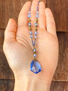 The loop of the clasp on this necklace is marked, 'Czechoslovakia' and it feels old and well made when held. The glass is a periwinkle blue and there is a faceted teardrop pendant at the bottom with a decorative metal top. The beads on the strand are both small and round, and long and cylindrical. There are also small, spherical, gold toned beads with a swirled texture. There is some corrosion around the clasp and a small chip on the pendant. The necklace is being sold As Is for this reason. It Antique Beaded Necklace With Faceted Beads As Gift, Antique Beaded Necklaces With Faceted Beads As Gift, Antique Beaded Necklace With Faceted Beads For Gift, Vintage Crystal Necklaces With Polished Beads As Gift, Vintage Crystal Necklaces With Polished Beads For Gift, Vintage Crystal Necklace With Polished Beads As Gift, Vintage Crystal Necklace With Polished Beads For Gift, Vintage Necklace With Polished Beads, Vintage Czech Glass Beaded Necklaces With Polished Beads