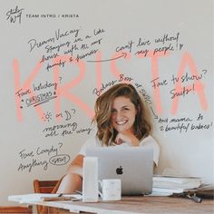 a woman sitting in front of a laptop computer on top of a wooden table next to a white wall