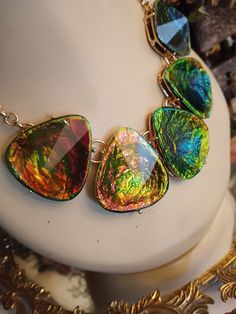 "A beautiful dichroic faceted glass necklace with five large teardrop 1 3/4\" long and 1 1/2\" at widest angle. All dichroic teardrops are gold encased. The lenght of this stunning necklace is 17\" with a two inch extension. The dichroic glass is bronze, green, yellow in color. Colors looks different in lighting. The earrings measure 1\" long and 1 1/4\" wide. All pieces are in beautiful condition. Wow! This set is a stunner. A great look for any occasion." Nickel-free Teardrop Glass Jewelry, Nickel-free Glass Teardrop Jewelry, Hypoallergenic Teardrop Glass Jewelry, Unique Czech Glass Jewelry For Party, Unique Iridescent Glass Necklaces, Adjustable Iridescent Glass Jewelry, Multicolor Faceted Jewelry For Party, Faceted Drop Jewelry For Party, Teardrop Glass Beads For Jewelry Making