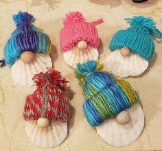 four knitted sea shells with hats on them