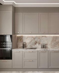 a kitchen with grey cabinets and marble counter tops