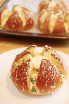 bread with cheese and spinach on it sitting on a plate next to other rolls