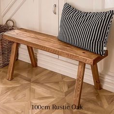 a wooden bench with a black and white striped pillow on it next to a basket