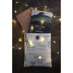 a book bag with some books in it on a table next to a string of lights