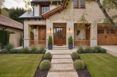 a house that is in the middle of some grass and plants on the front lawn