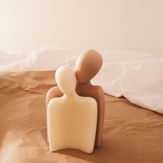 a small white sculpture sitting on top of a bed