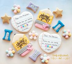 decorated cookies with thank you notes and other items on a white tablecloth, top view