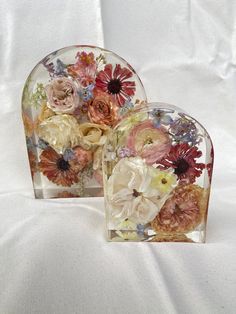 two heart shaped vases with flowers on them