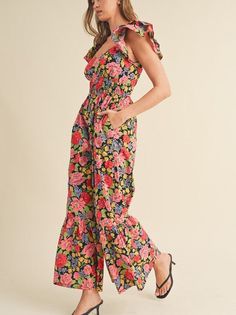 Let your confidence bloom in this flared ruffle hem jumpsuit. Sweetheart neckline and flutter sleeves add a touch of romance, while the tiered elastic waist panel accentuates your figure. Smocked back and pockets bring practicality. With a cut-out on the back, this black floral jumpsuit is a charming and functional choice. Color: Black Floral Fabric: 100% Cotton Brand: &Merci Sizes: S-M-L, Regular Sizing. Model is 5' 10.5" 32-24-36 and wears a S Casual Ruffled Jumpsuits And Rompers, Black V-neck Jumpsuits And Rompers With Ruffles, Spring Ruffle Sleeve Jumpsuits And Rompers With Ruffles, Spring Casual Jumpsuits And Rompers With Ruffle Hem, Casual Jumpsuits And Rompers With Ruffle Hem For Vacation, Summer Flutter Sleeve Jumpsuits And Rompers With Ruffles, Summer Ruffled Jumpsuits And Rompers With Flutter Sleeves, Casual Black Jumpsuits And Rompers With Ruffles, Casual Black Jumpsuit With Ruffles