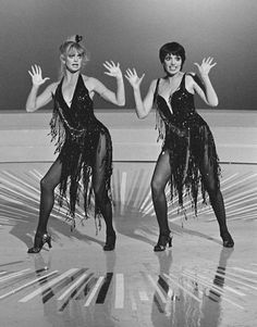 two women dressed in black dancing on stage