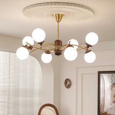 a chandelier hanging from the ceiling in a room with white walls and windows