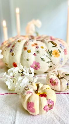 some white pumpkins and flowers on a table