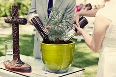 a man and woman are pouring water into a potted plant at an outdoor event