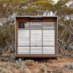 a small building in the middle of some brush