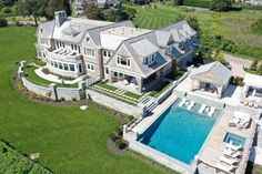 an aerial view of a large mansion with a swimming pool in the middle of it