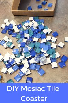 blue and white tiles are scattered on the floor next to a cardboard box that says diy mosaic tile coasters