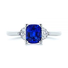 a blue sapphire and diamond ring on a white background