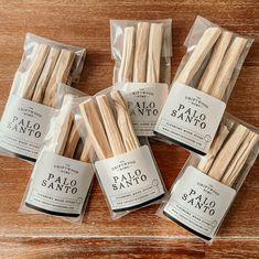 five packaged palo sano sticks on a wooden table