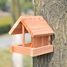 a wooden bird house attached to a tree