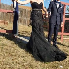 a woman in a black dress standing next to a man