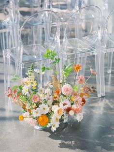 a vase filled with lots of flowers sitting on top of a table next to chairs