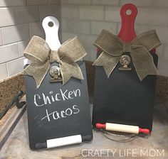 two chalkboards with the words chicken tacos written on them are sitting next to each other