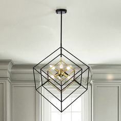 a chandelier hanging from the ceiling in a room with white walls and cabinets