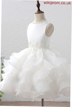 a white flower girl dress on a mannequin