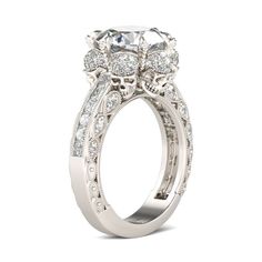 a white gold engagement ring with an oval center stone surrounded by round diamonds