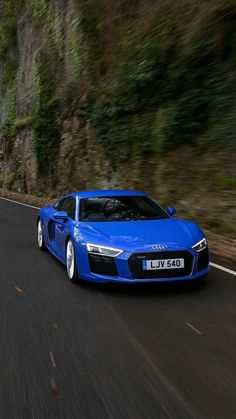 a blue sports car driving down the road