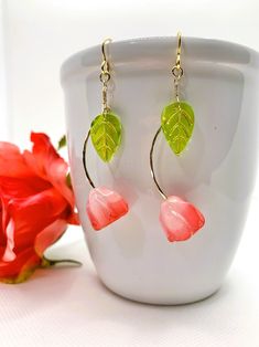 Beautiful long stem rose earrings in shades of pink with a green leaf to make the look complete. These lightweight earrings move freely while dangling from gold plated ear hooks.  Dress up any outfit with a pair of elegant rose earrings. Only one pair available so order now for yourself to as a gift for someone special in your life. Pink Rose Design Dangle Earrings, Pink Rose Design Drop Earrings, Pink Rose Earrings, Long Stem Rose, Beading Ideas, Earrings Pink, Lightweight Earrings, Earrings Long, Ear Hook