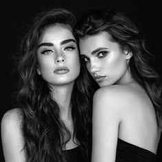 two beautiful young women standing next to each other with their arms around one another's shoulders