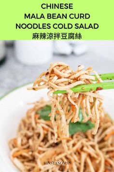 noodles and vegetables are being served in a white bowl with chopsticks on the side