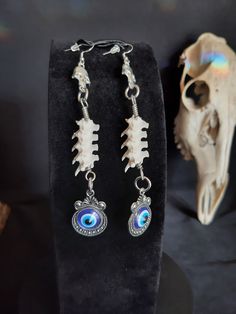 These are Gorgeous Evil Eye Earrings! They are Said to Keep Foul Energies and Intents Away From You. These Were Made with Real Rattlesnake Vertebrae. The Hooks Are Stainless Steel. These Earrings are 5 Inches Long. All Items Ship Within 1-3 Days via USPS First Class Service. Shipping on These Earrings Will be 5.00 Additional Items are Free! International Shipping Will Be 20.00, And All Additional Items Are FREE! International Shipping May Take 2 - 6 Weeks To Deliver. I Always Love to Accommodate Custom Orders! If you Have Something in Mind , Please Message me. Have a Drawing or a Photo of Your Inspiration and Send it to Me! And Also Please Send Me Your Preferred Budget For Your Piece, To Make Sure You are Not Overcharged. I DO NOT Carry Human Bones or Any Sort Of Illegal Items. And As Etsy Wiccan Earrings, Earrings Snake, Wiccan Necklace, Witch Necklace, Antler Necklace, Witch Earrings, Human Bones, Bone Earrings, Bone Necklace