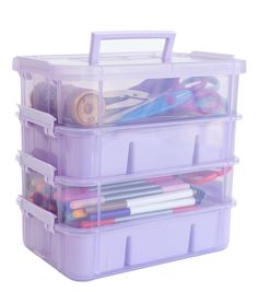 a purple plastic storage box filled with lots of crafting supplies and scissors on top of it