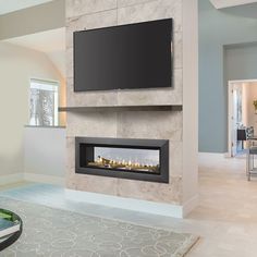 a living room with a large flat screen tv mounted on the wall next to a fireplace