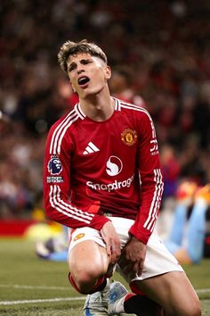 a young man sitting on top of a soccer field